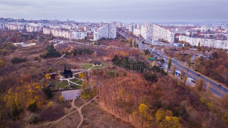 Aerial view of old wooden church in the autumn park over city. Drone shot. Moldova Kishinev. Aerial view of old wooden church in the autumn park over city. Drone shot. Moldova Kishinev