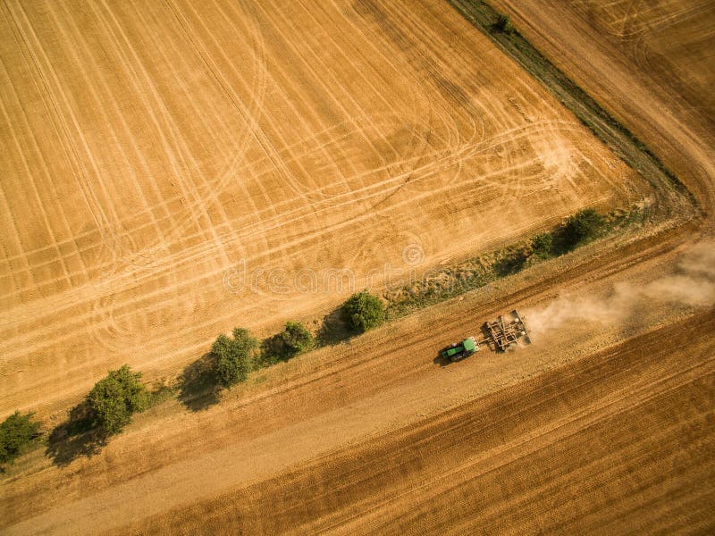 Vogelperspektive eines Traktors, der ein Feld bearbeitet stockbild Vogelperspektive eines Traktors, der ein Feld bearbeitet stockbild