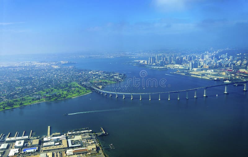 Aerial view of the Coronado island and bridge in the San Diego Bay in Southern California, United States of America. A view of the Skyline of the city and some boats crossing the the sea. Aerial view of the Coronado island and bridge in the San Diego Bay in Southern California, United States of America. A view of the Skyline of the city and some boats crossing the the sea.