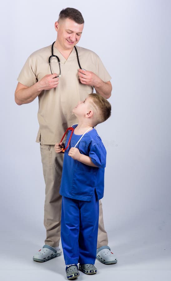 Voglia essere medico come papà Il bambino sveglio gioca al dottore il gioco Medico di famiglia Concetto del pediatra Medico del p fotografie stock Voglia essere medico come papà Il bambino sveglio gioca al dottore il gioco Medico di famiglia Concetto del pediatra Medico del p fotografie stock