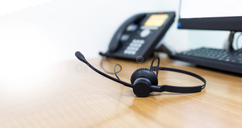 VOIP headset for callcenter on desk at customer service office. Communication support for sale support and telemaketing Helpdeskac