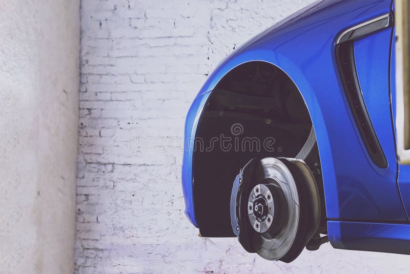 Voiture bleue dans la station service pour le pneu, la suspension et les freins