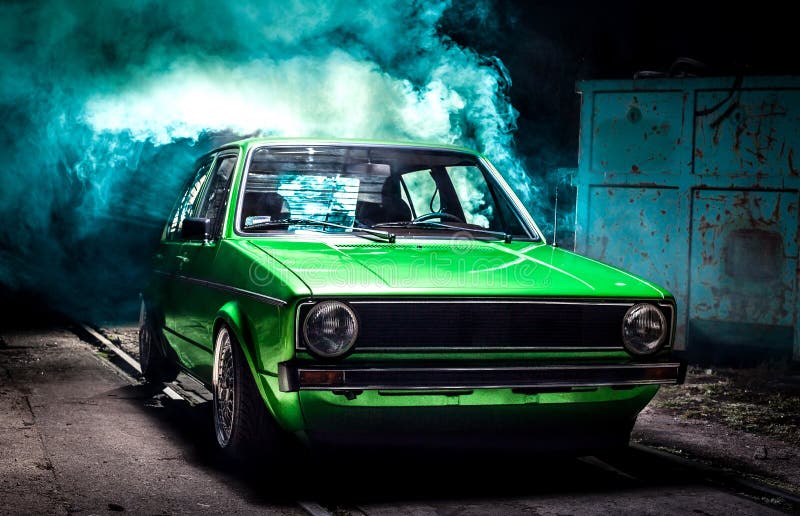 Small classic green car emerging from the smoke. I took the picture using two flashes and a smoke flare. Camera: Canon 5D mark 2, 50 lens. Small classic green car emerging from the smoke. I took the picture using two flashes and a smoke flare. Camera: Canon 5D mark 2, 50 lens
