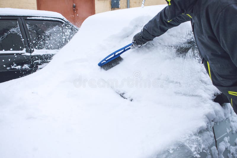 Voiture de nettoyage d'homme de neige et glace avec l'outil de brosse et de grattoir pendant les chutes de neige Urgence d'hiver photo libre de droits Voiture de nettoyage d'homme de neige et glace avec l'outil de brosse et de grattoir pendant les chutes de neige Urgence d'hiver photo libre de droits
