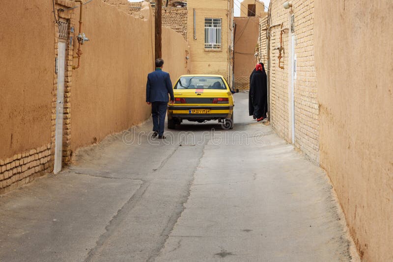 Voiture et personnes iraniennes sur la rue étroite de la vieille ville dans Yazd l'iran photographie stock Voiture et personnes iraniennes sur la rue étroite de la vieille ville dans Yazd l'iran photographie stock
