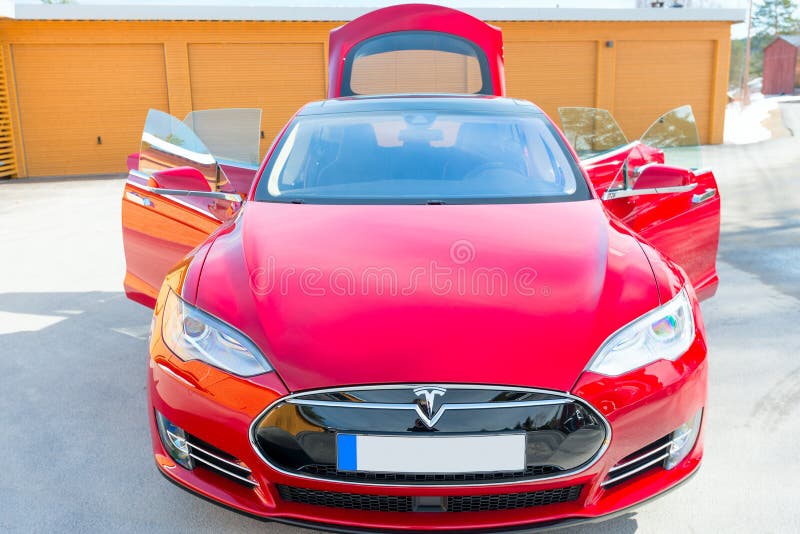 ASKER, NORWAY - MARCH 31: Tesla Motors model S sedan electric red car on March 31, 2015. Tesla's new Gigafactory would help Tesla increase its monthly production volume to 20,000 cars per month. ASKER, NORWAY - MARCH 31: Tesla Motors model S sedan electric red car on March 31, 2015. Tesla's new Gigafactory would help Tesla increase its monthly production volume to 20,000 cars per month.