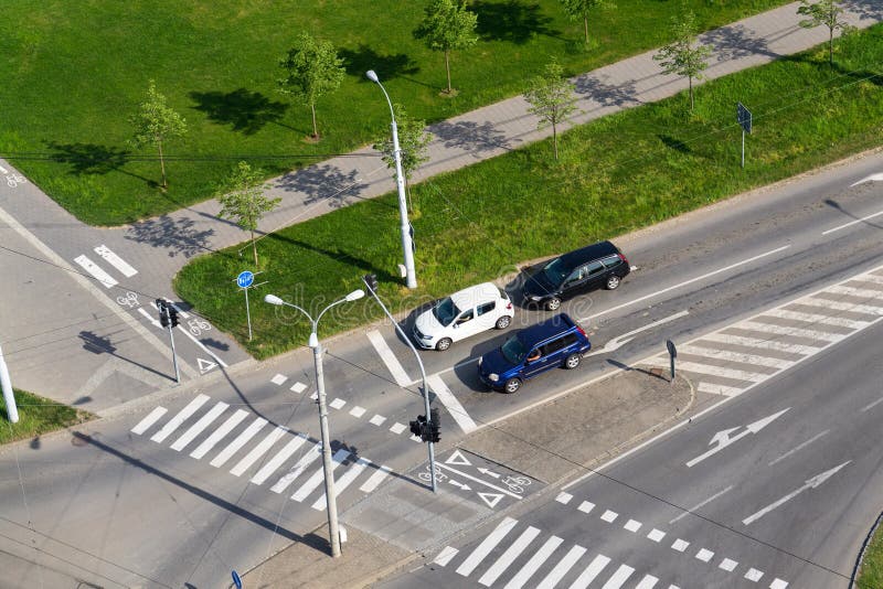 Aerial view of cars waiting in front of crosswalk and bike crossing line on crossroad, driverless technology concept. Aerial view of cars waiting in front of crosswalk and bike crossing line on crossroad, driverless technology concept