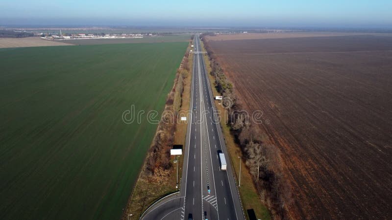 Vol avec vue aérienne sur route entre les champs par beau temps. banque de vidéos