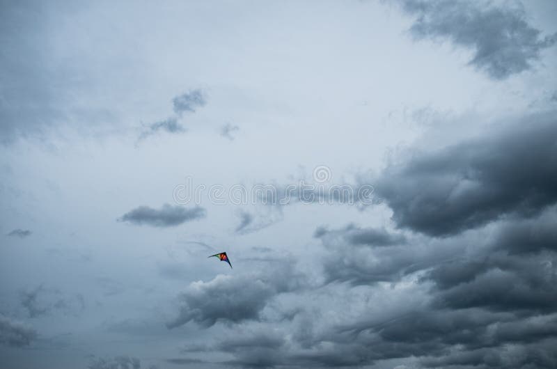 Vol coloré de cerf-volant dans un ciel orageux nuageux photographie stock libre de droits Vol coloré de cerf-volant dans un ciel orageux nuageux photographie stock libre de droits