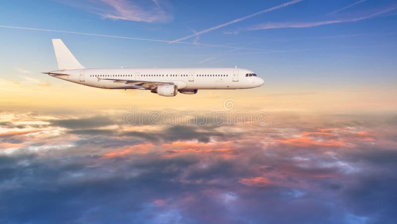 Vol d'avion de ligne à réaction d'avion au-dessus des nuages dans la belle lumière de coucher du soleil image libre de droits Vol d'avion de ligne à réaction d'avion au-dessus des nuages dans la belle lumière de coucher du soleil image libre de droits
