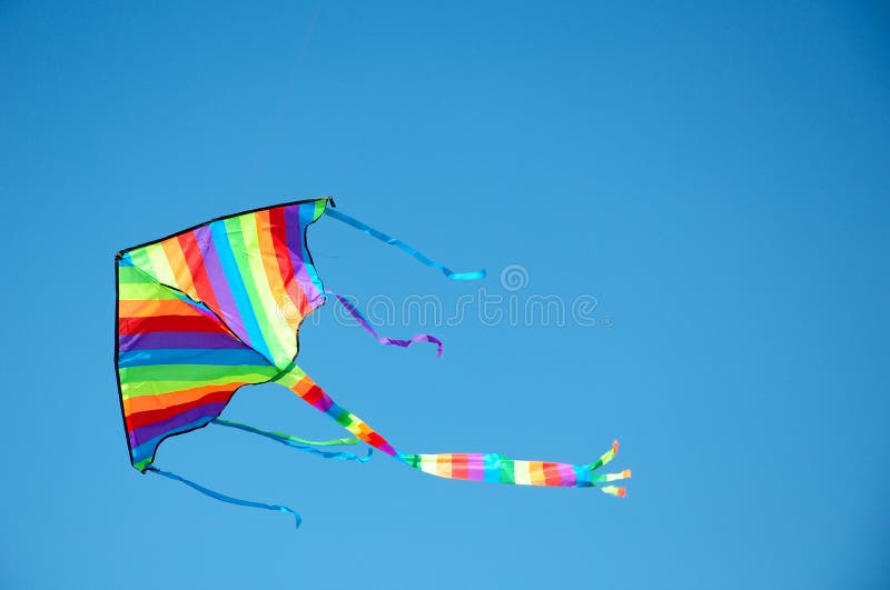 Stripped kite flying in the blue sky, fun for children. Stripped kite flying in the blue sky, fun for children.