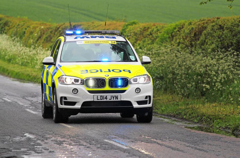 Volante della polizia di emergenza con il lampeggiamento blu delle luci immagine stock Volante della polizia di emergenza con il lampeggiamento blu delle luci immagine stock