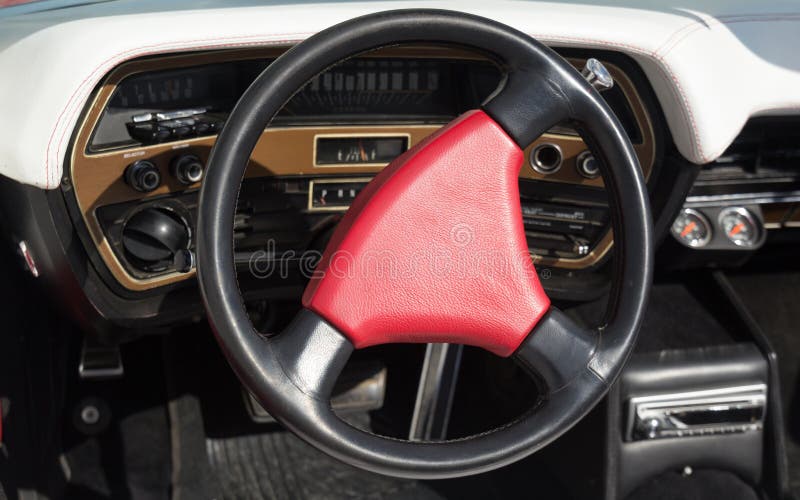 Volante vermelho em um carro elegante velho fotografia de stock Volante vermelho em um carro elegante velho fotografia de stock