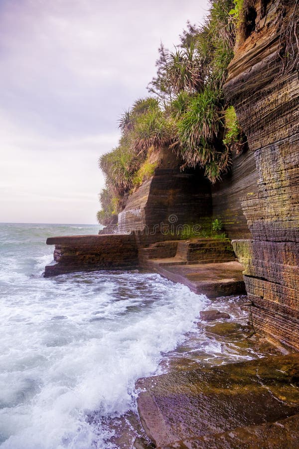 Volcanic cliff with sea waves