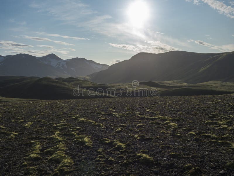 Volcanic landscape with snow covered mountains, green hills and lava gravel ground covered by lush moss. Fjallabak stock photos Volcanic landscape with snow covered mountains, green hills and lava gravel ground covered by lush moss. Fjallabak stock photos