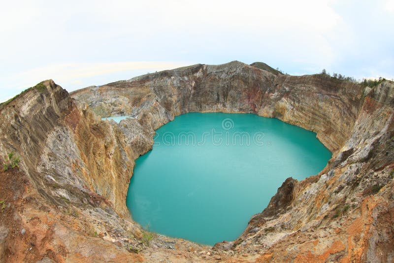 Green cool acid-brine lake Tin - Tiwu Nua Moori Koohi Fah - and white acid-saline lake Tap - Tiwu Ata Polo - colored by volcanic gases in volcanoes of mountain Kelimutu on Flores, Nusa Tengara Timur - NTT, Indonesia. Green cool acid-brine lake Tin - Tiwu Nua Moori Koohi Fah - and white acid-saline lake Tap - Tiwu Ata Polo - colored by volcanic gases in volcanoes of mountain Kelimutu on Flores, Nusa Tengara Timur - NTT, Indonesia