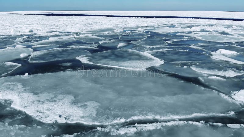 Voler au-dessus de la glace de mer de flottement le jour ensoleillé Inclinaison d'appareil-photo