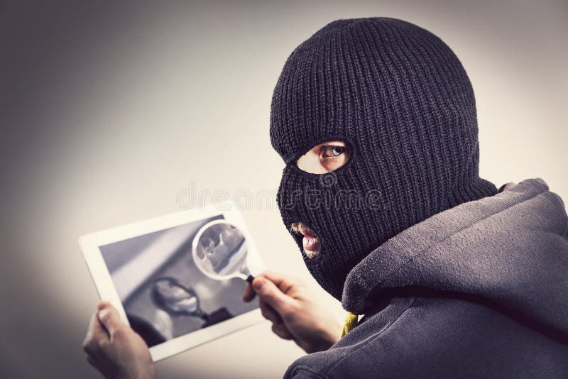 Voleur entaillant la sécurité de mobile de comprimé photographie stock libre de droits Voleur entaillant la sécurité de mobile de comprimé photographie stock libre de droits