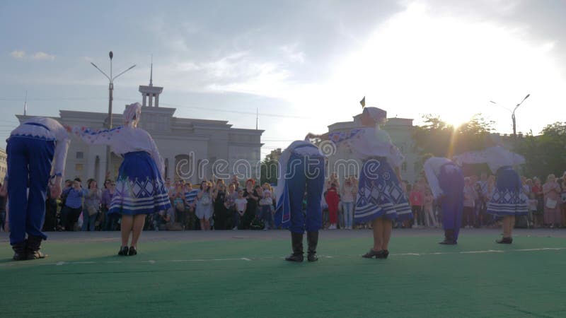 Volksfestlichkeiten, Jungen und Mädchen in den nationalen Kostümen tanzen hopak in Stadtplatz vor Mengenleuten am Feiertag