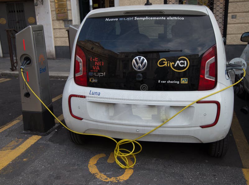 Volkswagen e-Up plug-in hybrid electric car stands by charging station, in Genoa, Italy. stock images Volkswagen e-Up plug-in hybrid electric car stands by charging station, in Genoa, Italy. stock images