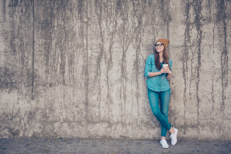 Volledig - grootte die van vrolijke jonge dame, zich dichtbij concrete muurou bevinden royalty-vrije stock foto Volledig - grootte die van vrolijke jonge dame, zich dichtbij concrete muurou bevinden royalty-vrije stock foto