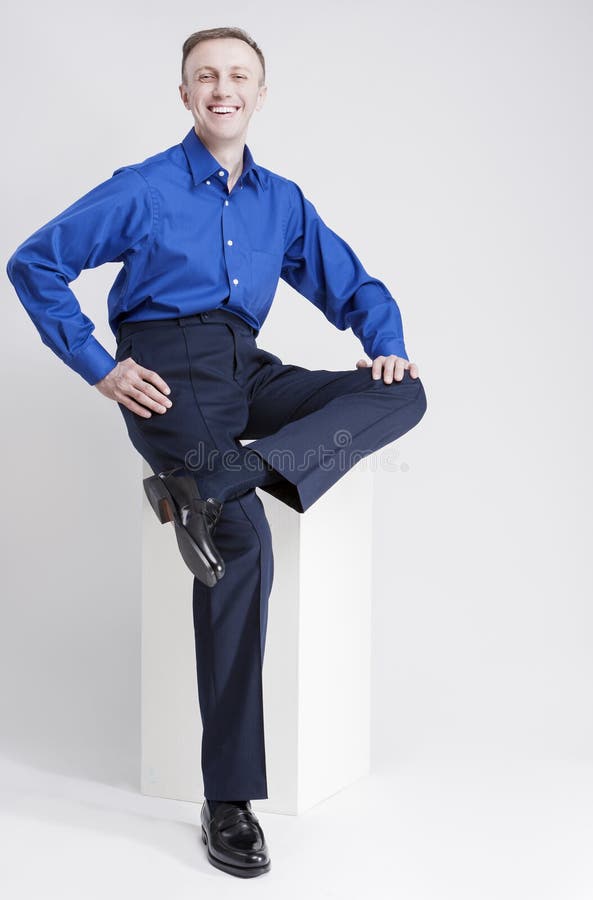 Volledig Lengteportret van het Glimlachen Kaukasische Mensenzitting op Witte Doos en het Lachen stock foto Volledig Lengteportret van het Glimlachen Kaukasische Mensenzitting op Witte Doos en het Lachen stock foto