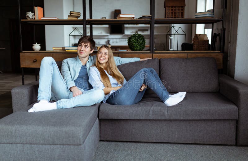 Volledig - rangschik portret van aantrekkelijke in paarzitting in moderne open plekflat royalty-vrije stock afbeeldingen Volledig - rangschik portret van aantrekkelijke in paarzitting in moderne open plekflat royalty-vrije stock afbeeldingen