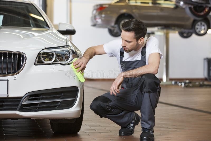 In voller Länge vom Wartungstechnikerreinigungsauto in der Werkstatt stockbilder In voller Länge vom Wartungstechnikerreinigungsauto in der Werkstatt stockbilder