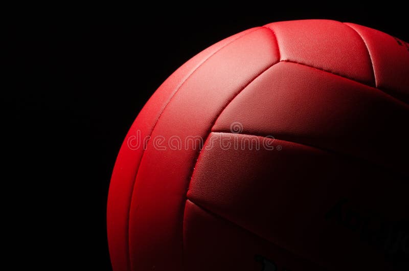 Red volley ball against a black background