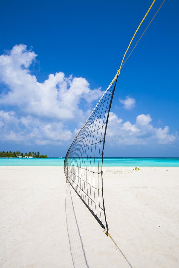 View from a volleyball net at the beach to a tropical island in the turquoise sea