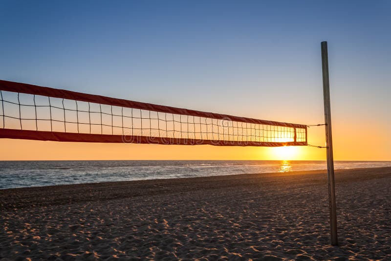 Volleyball net on the beach with the sunset