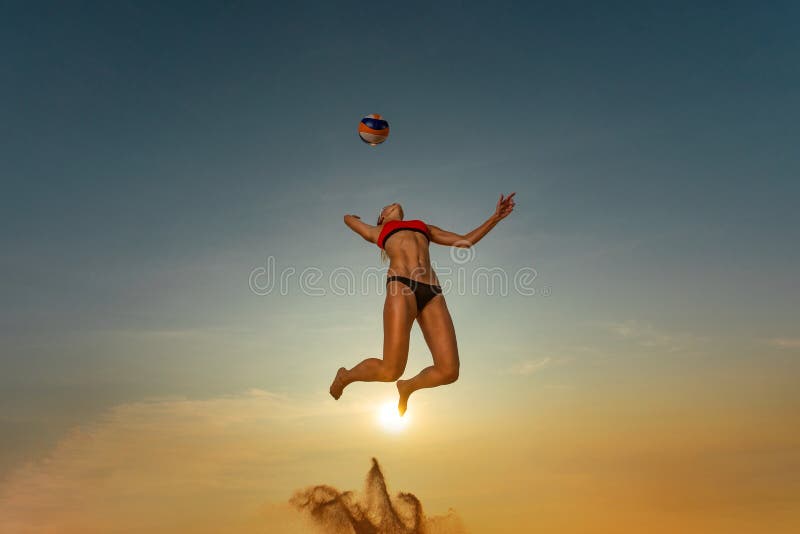 Volleyball player. Jump of young girl, playing volleyball on the beach.