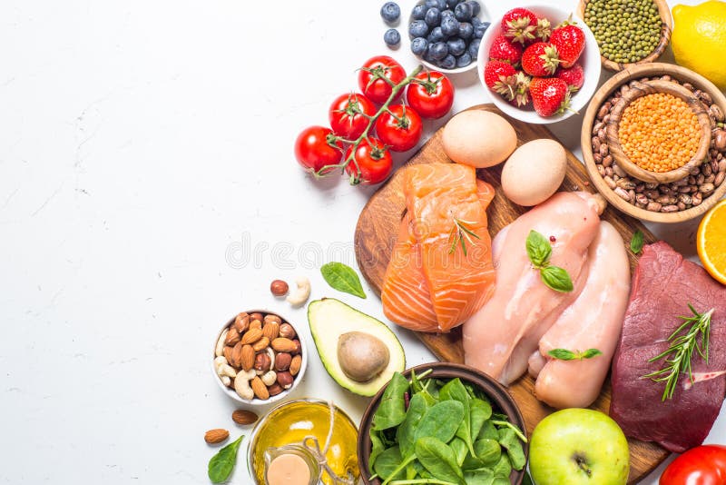 Balanced diet food background. Healthy nutrition. Ketogenic low carbs diet. Meat, fish, nuts, vegetables, oil, beans, lentils fruits and berries on white background. Top view. Balanced diet food background. Healthy nutrition. Ketogenic low carbs diet. Meat, fish, nuts, vegetables, oil, beans, lentils fruits and berries on white background. Top view