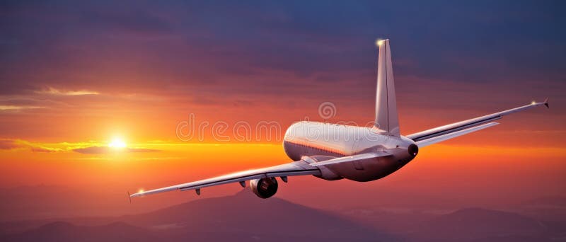 Volo commerciale dell'aeroplano sopra le montagne nel tramonto