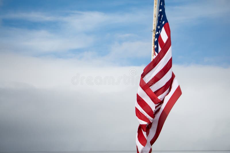 Volo della bandiera americana sul fondo del cielo blu fotografia stock libera da diritti Volo della bandiera americana sul fondo del cielo blu fotografia stock libera da diritti