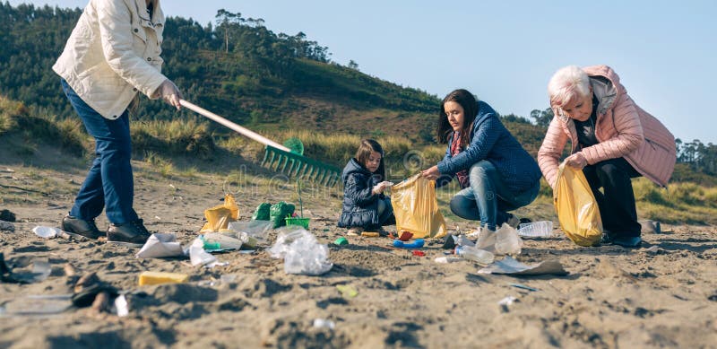 Volontaires féminines nettoyer la plage. Groupe de volontaires pour femmes prenant des déchets sur la plage