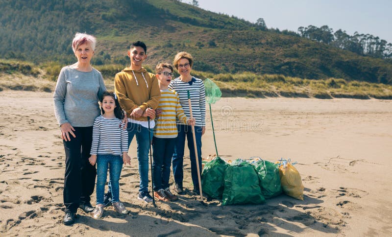 Volontaires posant après le nettoyage de la plage image stock