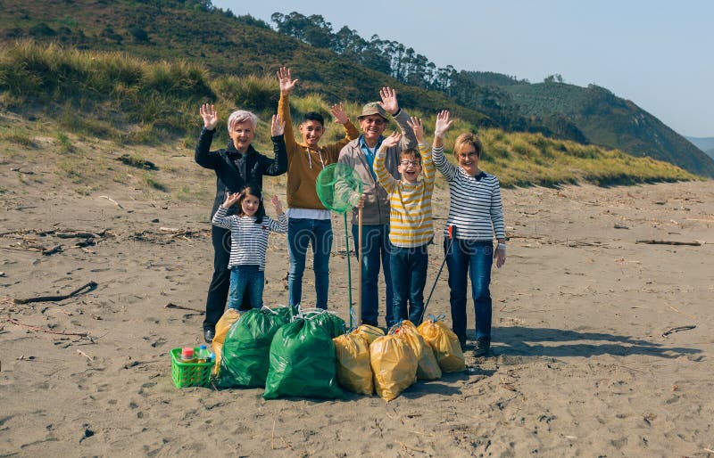 Volontaires posant après le nettoyage de la plage image stock