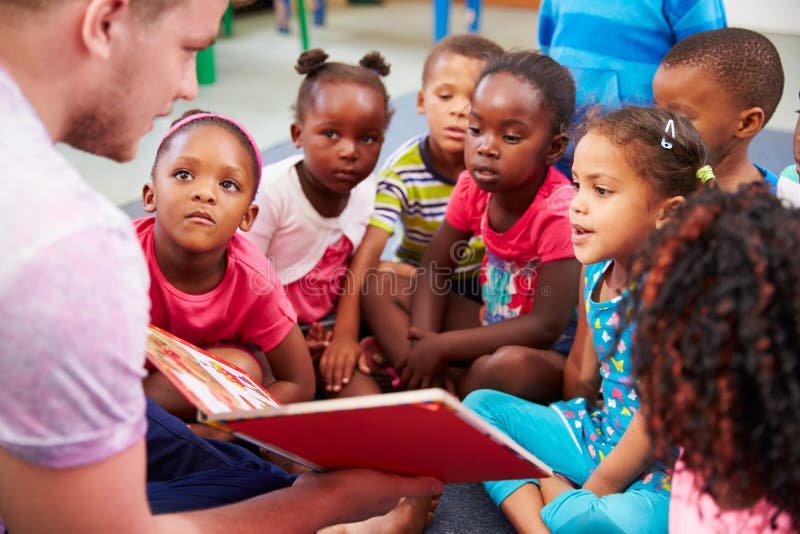 Voluntario el maestro lectura sobre el la clase de jardín de infancia.