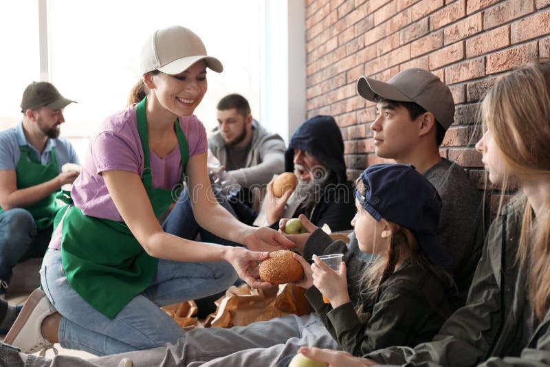Volunteers giving food to poor people stock photo Volunteers giving food to poor people stock photo
