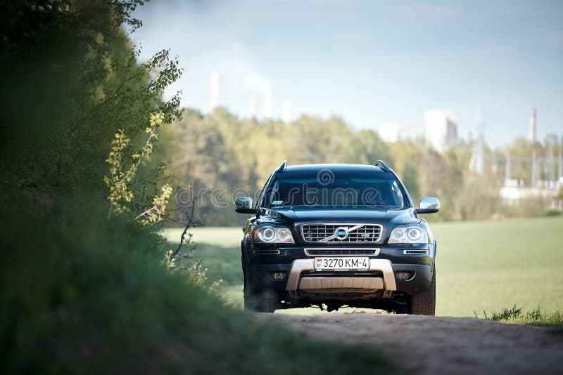 GRODNO, BELARUS - MAY 2015: Volvo XC90 4.4 v8 1st generation restyling 4WD SUV test drive in spring field country road on forest background with tubes and smoke in Grodno Belarus. GRODNO, BELARUS - MAY 2015: Volvo XC90 4.4 v8 1st generation restyling 4WD SUV test drive in spring field country road on forest background with tubes and smoke in Grodno Belarus