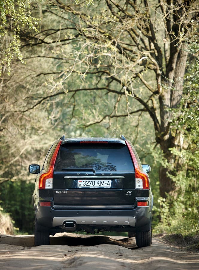 GRODNO, BELARUS - MAY 2015: Volvo XC90 4.4 v8 1st generation restyling 4WD SUV test drive in spring country road with bumps on forest background back view in Grodno Belarus. GRODNO, BELARUS - MAY 2015: Volvo XC90 4.4 v8 1st generation restyling 4WD SUV test drive in spring country road with bumps on forest background back view in Grodno Belarus
