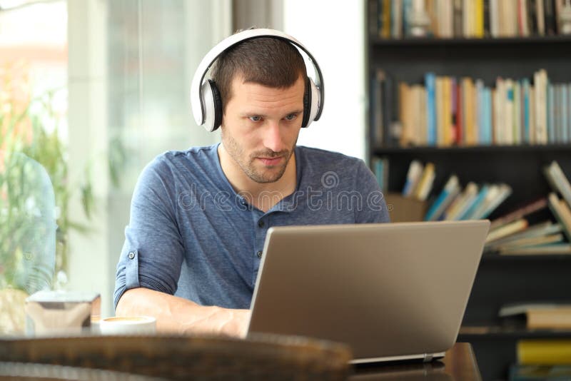 Volwassen man die een hoofdtelefoon draagt met een laptop