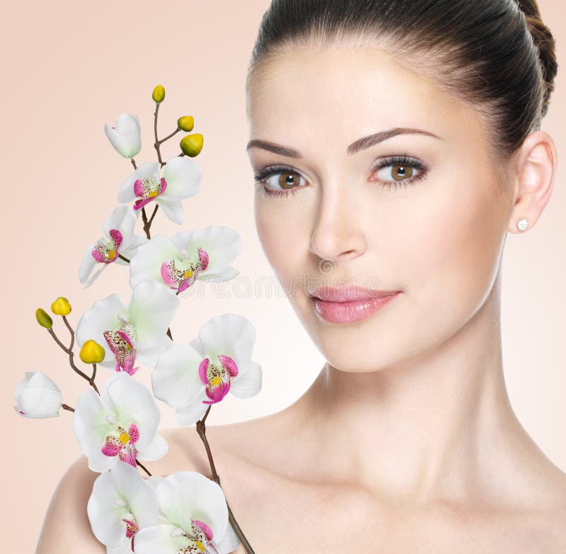 Volwassen vrouw met mooie gezicht en bloemen stock foto Volwassen vrouw met mooie gezicht en bloemen stock foto