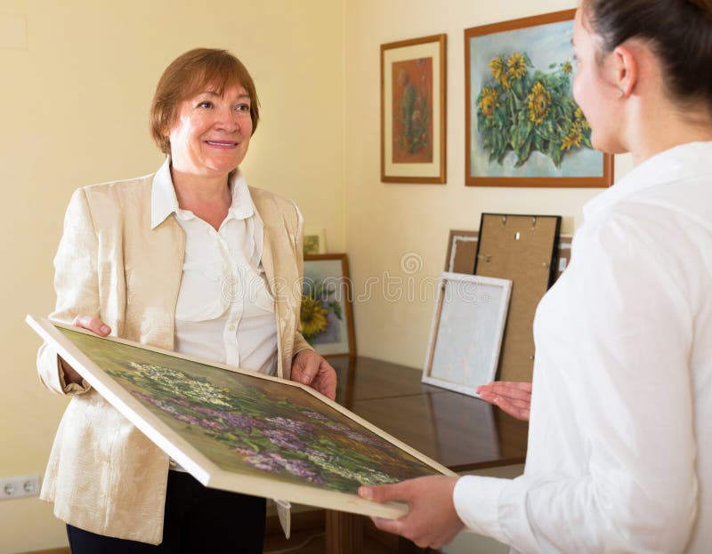 Volwassen wijfjes die het beeld in kunstgalerie bekijken stock fotografie Volwassen wijfjes die het beeld in kunstgalerie bekijken stock fotografie