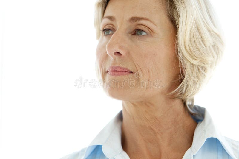 Portrait of a middle-aged Caucasian woman looking away. She is in her fifties and has blue eyes and short blond hair. She also wears a blue shirt. Isolated on white with copy space. Portrait of a middle-aged Caucasian woman looking away. She is in her fifties and has blue eyes and short blond hair. She also wears a blue shirt. Isolated on white with copy space.