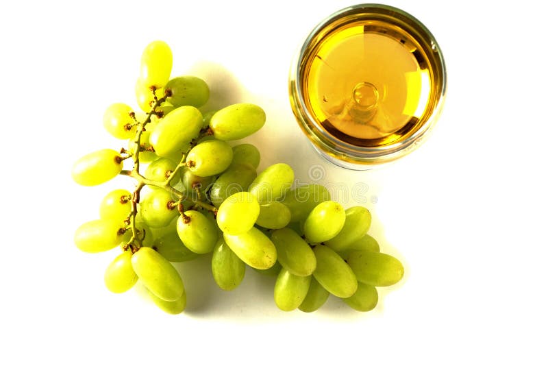 Von oben nach unten auf einem Glas Weißwein und einem Haufen von frischen grünen Trauben auf weißem, isoliertem Hintergrund. Produ stockfotografie