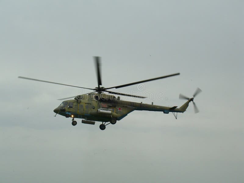Voo militar do helicóptero do grande russo contra o céu cinzento fotografia de stock Voo militar do helicóptero do grande russo contra o céu cinzento fotografia de stock