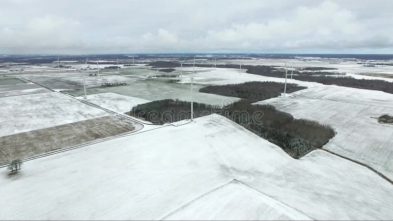 Voo sobre o moinho de vento em Lituânia Estação atrasada do inverno no fundo