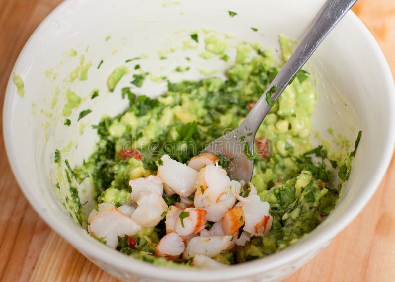 Voorbereiding van avocado en garnalensalsa stock foto's